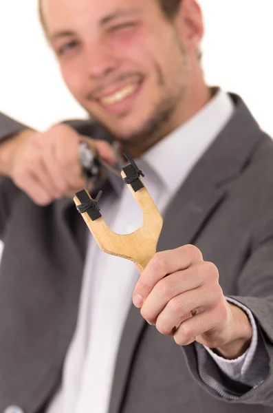 Handsome buisness man smiling concentrated aiming a slingshot isolated over white background — Φωτογραφία Αρχείου