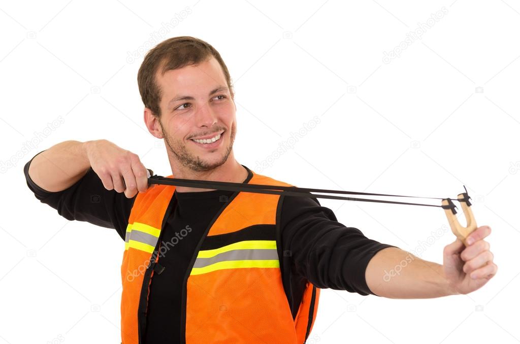Handsome man concentrated aiming a slingshot with security vest isolated over white background