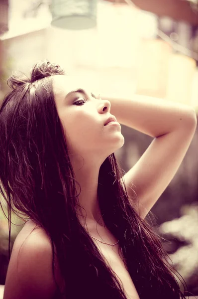 Lindo headshot do modelo latina inclinando a cabeça para trás com mão tocando o cabelo do ângulo lateral — Fotografia de Stock