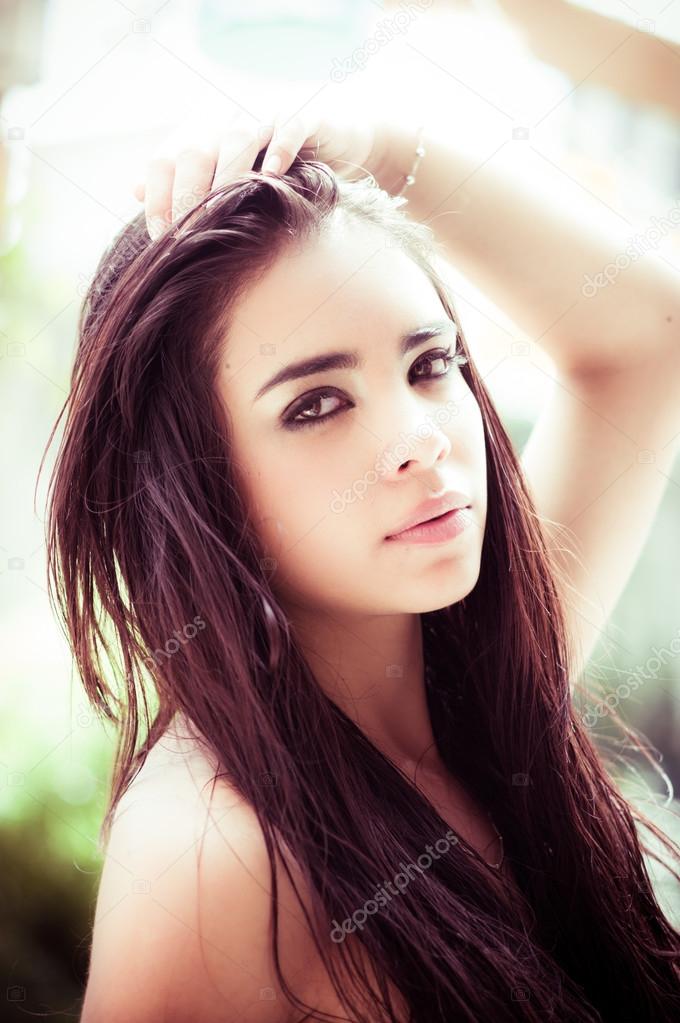 Beautiful headshot of latina model looking into camera with seductive dark eyes from side angle