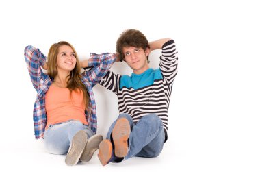 Portrait of attractive young happy couple in love man and woman isolated over white background sitting on floor looking up relaxing hands back their heads dreaming 