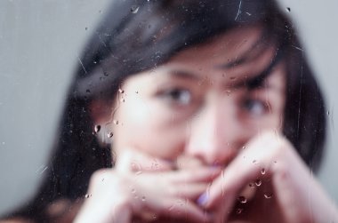 Bulanık ıslak cam arkasında yalnız kız portresi