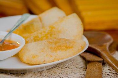 Üç empanadas güzel yanındaki küçük salsa kase ve rustik arka plan beyaz tabakta düzenlenmiş