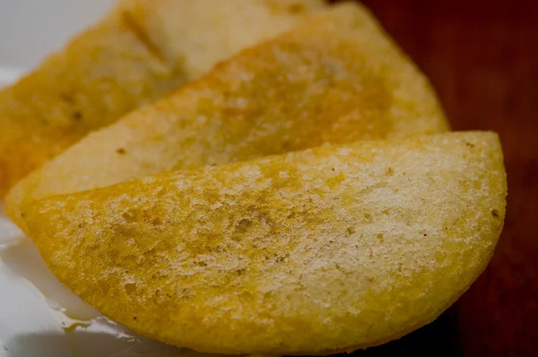 Closeup tři dokonalé empanadas na bílé plotně s dřevěnými povrchu pozadí — Stock fotografie