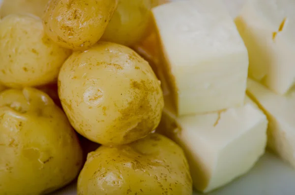 Gros plan boules fraîchement préparées de banane verte et morceaux de fromage frais sur assiette blanche — Photo