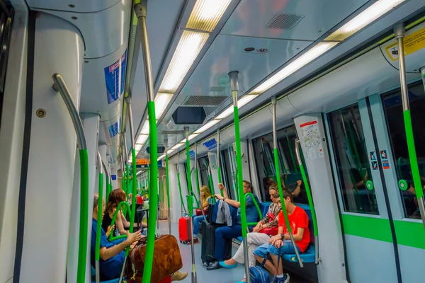 MADRID, SPAGNA - 8 AGOSTO 2015: All'interno del vagone della metropolitana in partenza dalla stazione di Barajas Airport con alcune persone sedute intorno — Foto Stock