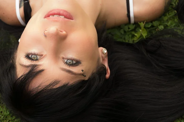 Brunette headshot close-up liggend op het gras op zoek naar boven rusten — Stockfoto