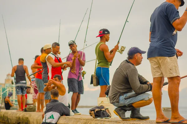 LA HABANA, CUBA - 30 de agosto de 2015: Hombres locales pescan en el mar en la ciudad de La Habana, muelle Malecón. La pesca es un pasatiempo común en Cuba . — Foto de Stock