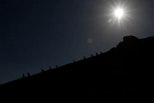 Siluetas de excursionistas en una montaña — Foto de Stock