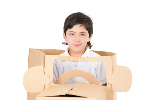 Beyaz arka plan üzerinde izole çalmaya karton arabada oturan sevimli genç çocuk — Stok fotoğraf