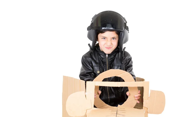 白い背景上分離再生段ボール車に座ってパイロットの衣装で身を包んだ愛らしい少年 — ストック写真