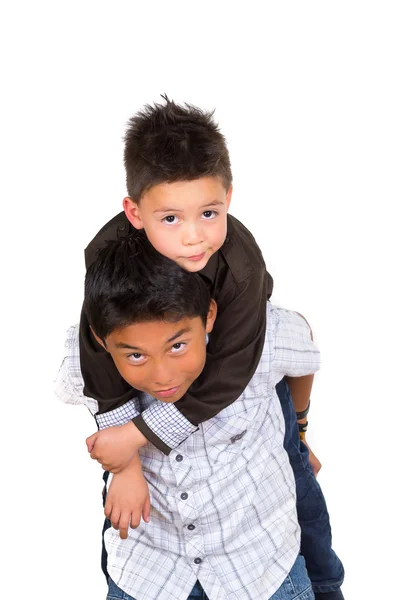 Deux petits garçons hispaniques jouant, l'un portant l'autre sur son dos, face à la caméra — Photo
