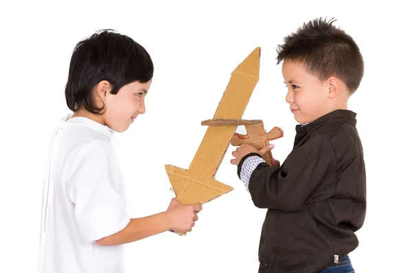Два маленьких мальчика симулируют бой на мечах с помощью игрушек и самодельного щита, белый фон — стоковое фото