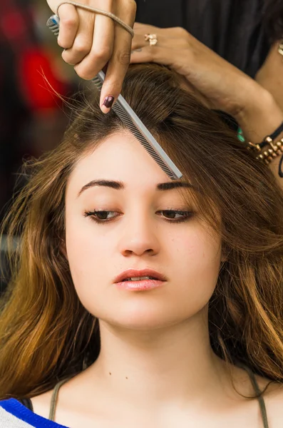 Brunette facing camera getting hair done by professional stylist — Φωτογραφία Αρχείου