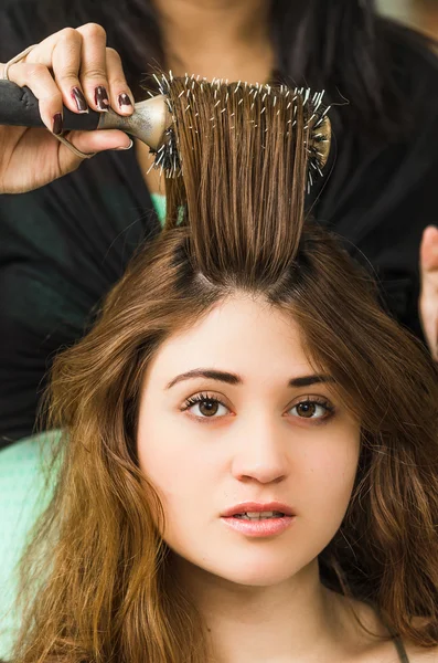 Brunette facing camera getting hair done by professional stylist — Φωτογραφία Αρχείου