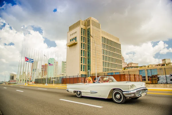 LA HABANA, CUBA - 30 de agosto de 2015: Viejos coches clásicos americanos utilizados para el transporte de taxis y turistas, Embajada de Estados Unidos en la parte trasera . — Foto de Stock