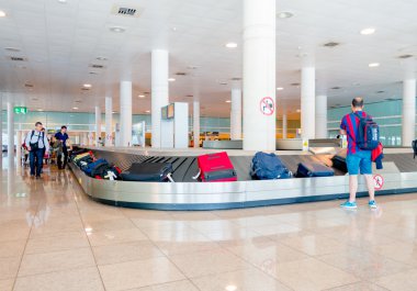Barcelona, İspanya - 8 Ağustos, 2015: Zincirleme makara kemer gelenler bagaj bavul ve içinde büyük parlak bekliyor etrafında insanlar için renkli Havaalanı'nda hall
