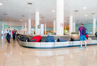 Barcelona, İspanya - 8 Ağustos, 2015: Zincirleme makara kemer gelenler bagaj bavul ve içinde büyük parlak bekliyor etrafında insanlar için renkli Havaalanı'nda hall