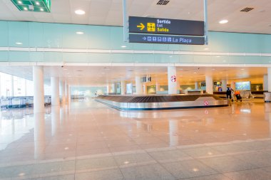Barcelona, İspanya - 8 Ağustos, 2015: Zincirleme makara kemer gelenler Bagaj içinde Havaalanı'nda büyük parlak renkli salonu için