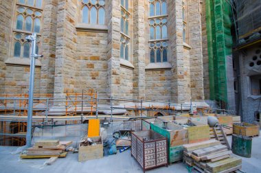 Small construction site with various building materials alongside La Sagrada Familia