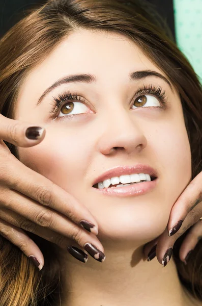 Closeup headshot brunette getting makeup treatment by professional stylist giving facial massage — ストック写真