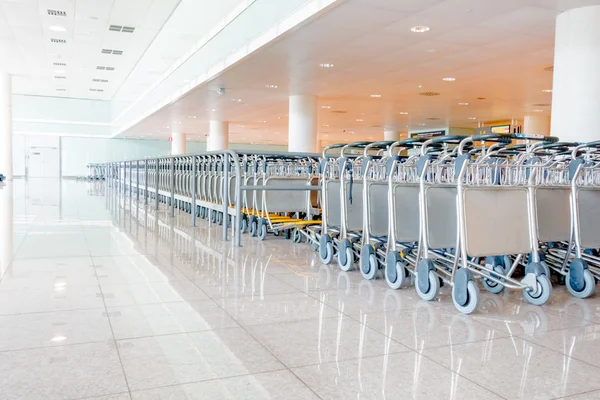 BARCELONA, ESPAÑA - 8 DE AGOSTO DE 2015: Líneas muy largas de carros de equipaje listos para ser utilizados por los viajeros en el aeropuerto — Foto de Stock