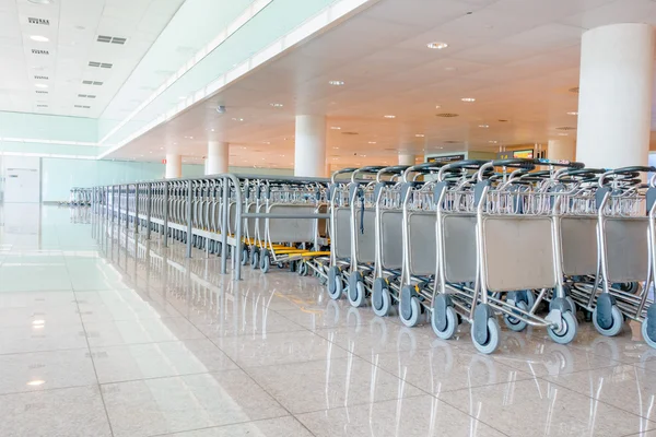 BARCELONA, ESPAÑA - 8 DE AGOSTO DE 2015: Líneas muy largas de carros de equipaje listos para ser utilizados por los viajeros en el aeropuerto — Foto de Stock