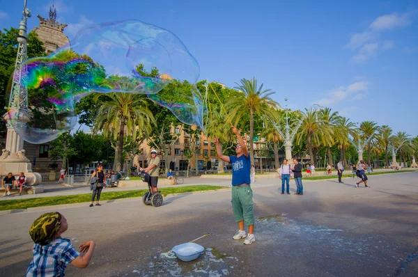 Beautiful wide avenue sorrounded by tall green palm trees and tourists enjoying a nice Barcelona sunny day — Stock Fotó