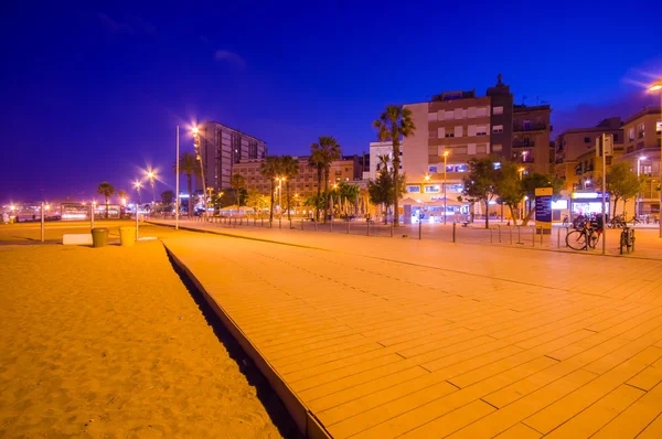 Vackra Barcelona beach avenue på natten i en charmig dusky gult ljus och klarblå himmel — Stockfoto