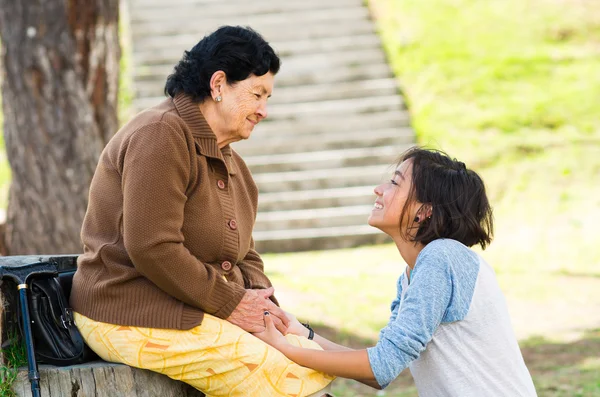 Großmutter mit Blick auf Enkelin, die Köpfe im Freien berührt, schönes Bild, das die Liebe zwischen den Menschen zeigt — Stockfoto