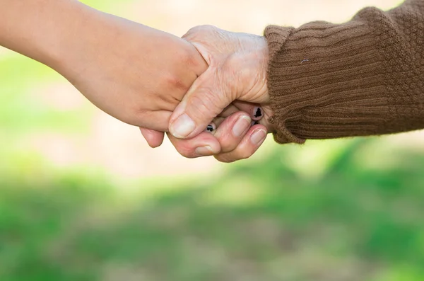 Gros plan grand-mère petite-fille tenant la main, environnement extérieur — Photo