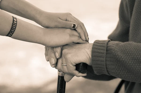 Closeup babička vnučka drží za ruce, venkovní prostředí černé a bílé vydání — Stock fotografie