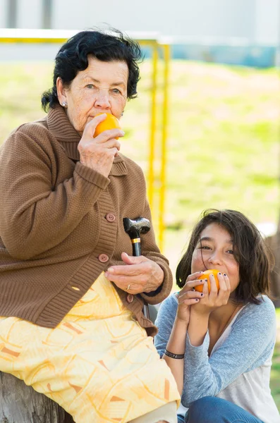 Großmutter Enkelin Qualitätszeit im Freien mit einer Orange — Stockfoto