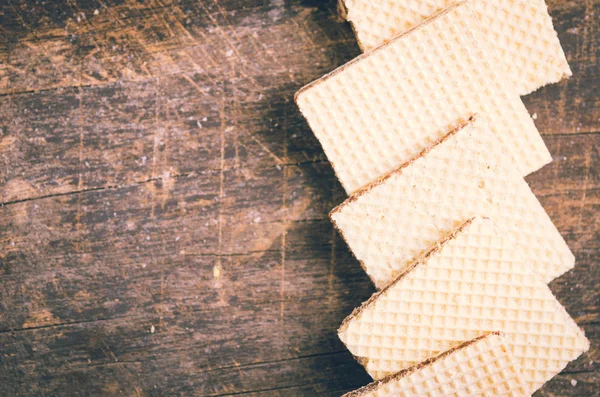 Biscuits carrés rapprochés se chevauchant l'un l'autre en rangée sur une surface en bois — Photo