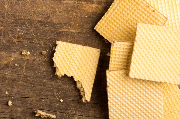 Pile of square cookies with one lying on the side half eaten, wooden surface — Stock Photo, Image