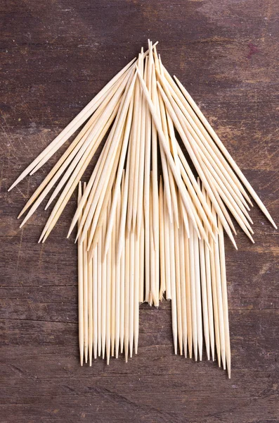 Bungalow simple hut type design from using toothpicks on dark wooden surface — Stock Fotó