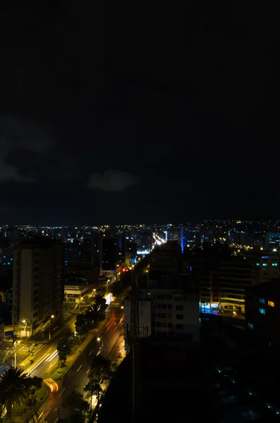 Photo fraîche de Quito la nuit montrant des parties de la ville avec des bâtiments éclairés skyline dans une lumière mystifiée bleu foncé — Photo