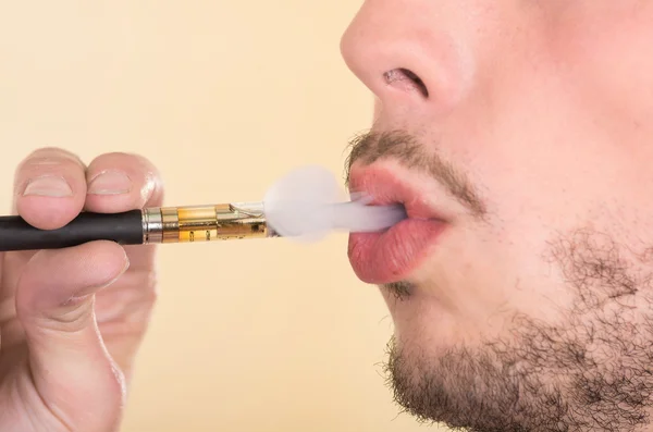 Closeup headshot of man smoking on electronic cigarette from profile angle — 图库照片