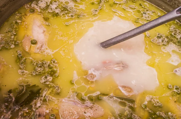 Zbliżenie, pyszne zupy ekwadorski z kolor żółty zawierających warzywa i mięso, metalowe narzędzia mieszając — Zdjęcie stockowe