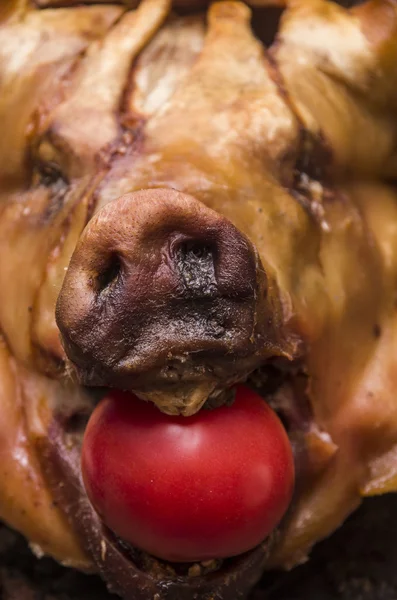 Cabeza de cerdo cocida desde el ángulo frontal con tomate rojo rellenado en su boca — Foto de Stock