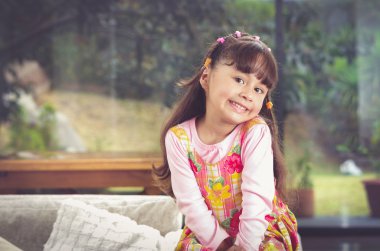 Pink giyim gülümseyen güzel genç İspanyol kız kameraya, bulanık Bahçe arka plan şirin