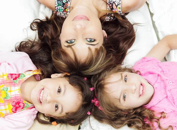 Jeunes adorables sœurs hispaniques avec la mère couchée, les têtes touchées et les corps étalés dans différentes directions gros plan — Photo