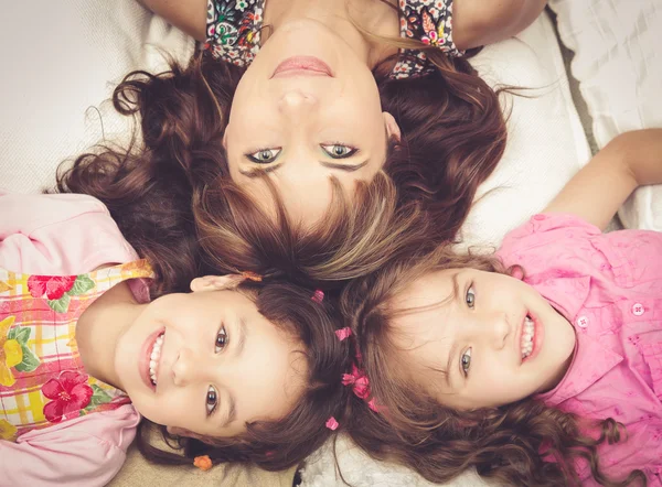 Young adorable hispanic sisters and mother lying down with heads touching, bodies spread out different directions closeup — Stock Photo, Image