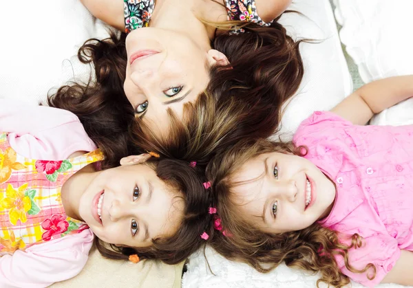 Jeunes adorables sœurs hispaniques avec la mère couchée, les têtes touchées et les corps étalés dans différentes directions gros plan — Photo