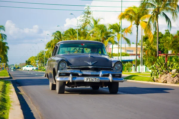 Cienfuegos, Cuba - 12 de septiembre de 2015: Coches clásicos todavía están en uso y viejos contadores de tiempo se han convertido en una icónica vista Imágenes de stock libres de derechos