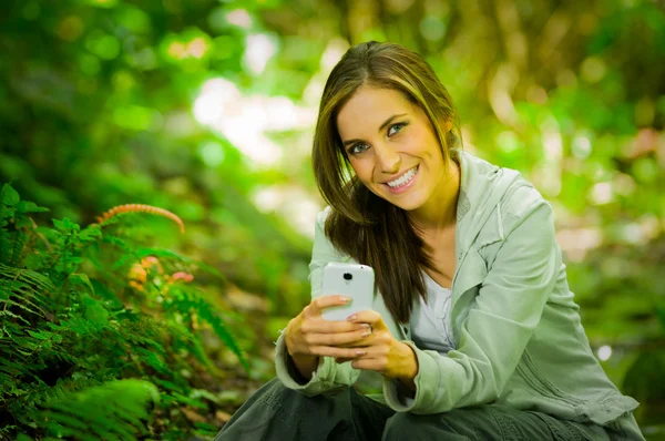 Hermosa joven disfrutando de una excelente conectividad en la selva — Foto de Stock