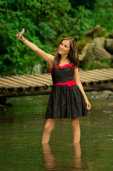 Beautiful young girl taking a selfie in the middle of jungle — Stock Photo, Image