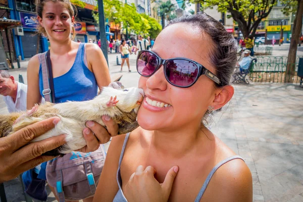 Unknown tourist getting a kiss from guinea pig in Botero Plaza, Medellin city, Colombia — Stock Photo, Image