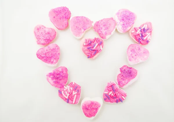 Lecker aussehende Kekse mit rosa Zuckerguss zu einer Herzformation geformt, Schuss von oben — Stockfoto