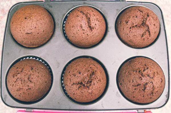 Délicieux cupcakes au chocolat frais tout droit sortis du four toujours assis à l'intérieur de la casserole en métal, tiré par le haut — Photo